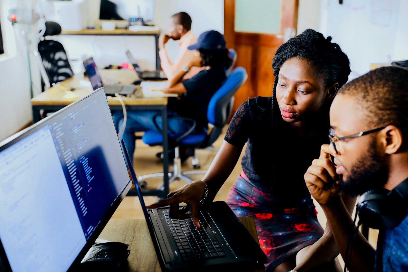 Two learners working through a scored budget drill on a laptop